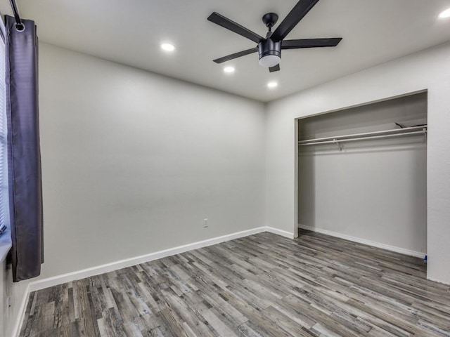 unfurnished bedroom featuring hardwood / wood-style flooring, ceiling fan, and a closet