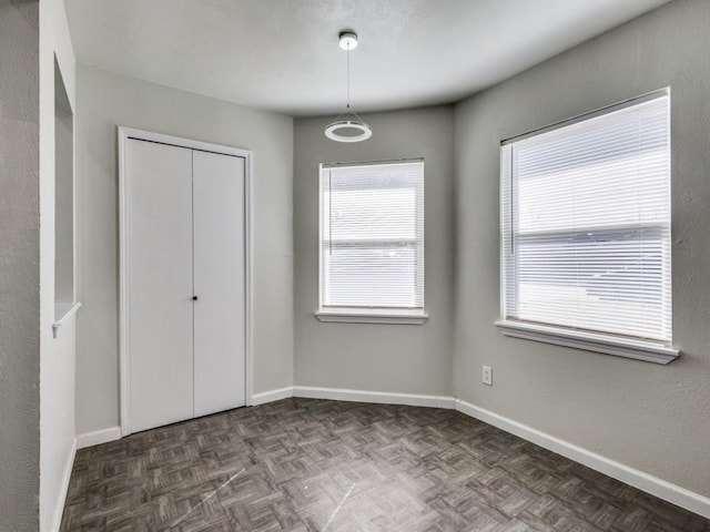 unfurnished bedroom with a closet and dark parquet floors