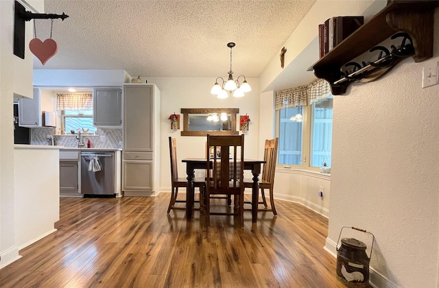 dining room with dark hardwood / wood-style flooring, a chandelier, and a textured ceiling