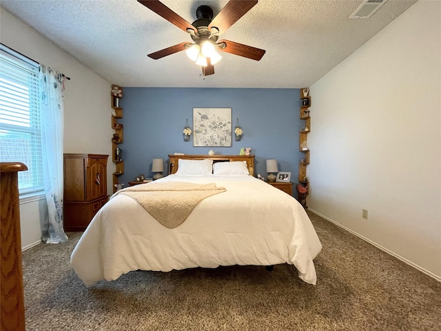 carpeted bedroom with multiple windows, a textured ceiling, and ceiling fan