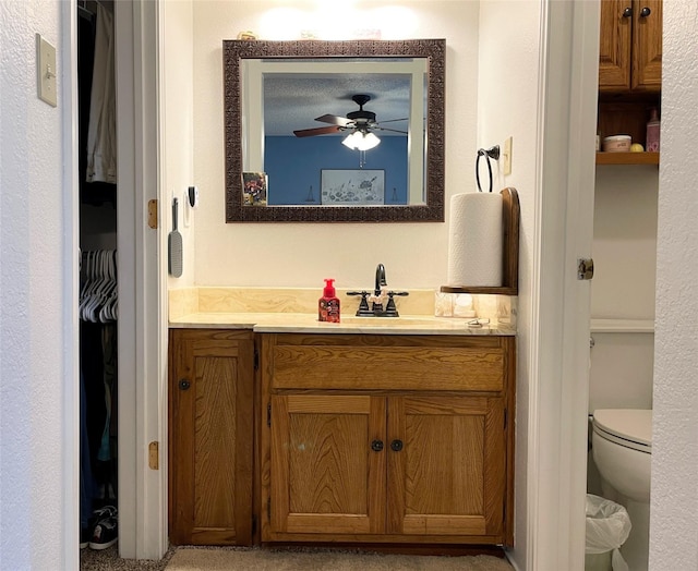 bathroom with vanity, ceiling fan, and toilet