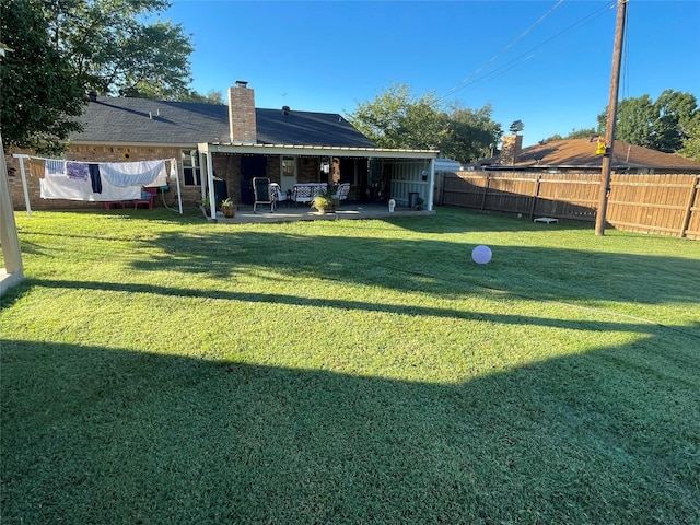 back of property featuring a yard and a patio