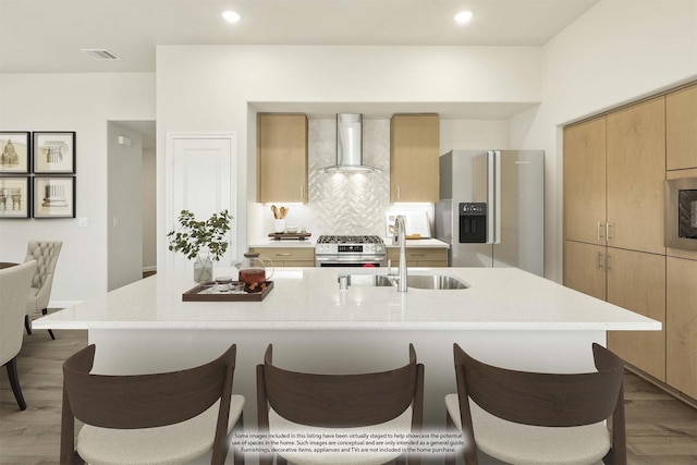 3219 Blossom Trl, Crandall, TX 75114 - kitchen with appliances with stainless steel finishes, wall chimney range hood, a sink, a breakfast bar, and light countertops