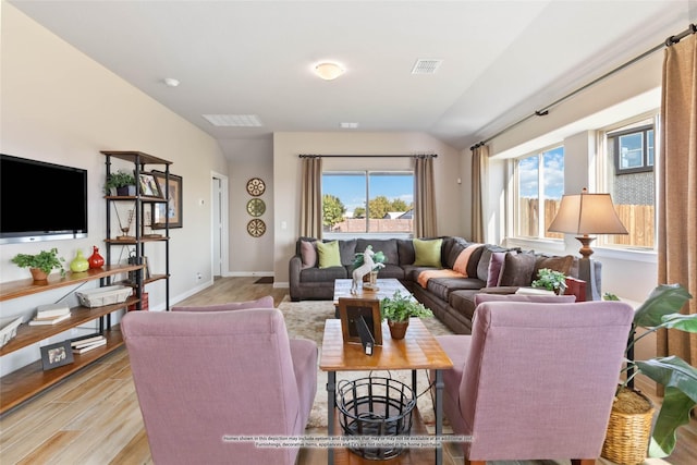 living room featuring vaulted ceiling and light wood-type flooring