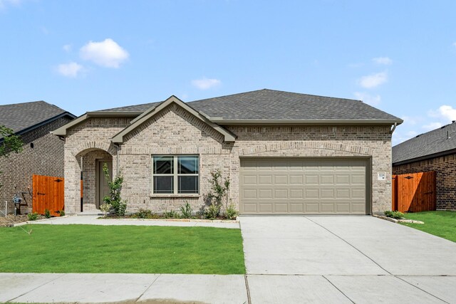 3219 Blossom Trl, Crandall, TX 75114 - french country inspired facade featuring a shingled roof, brick siding, driveway, and an attached garage