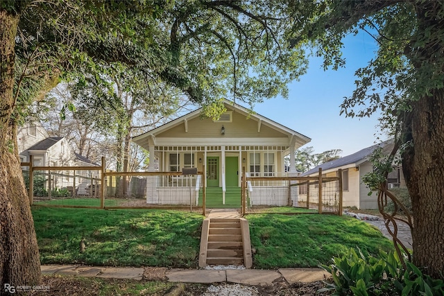 back of property with a yard and covered porch