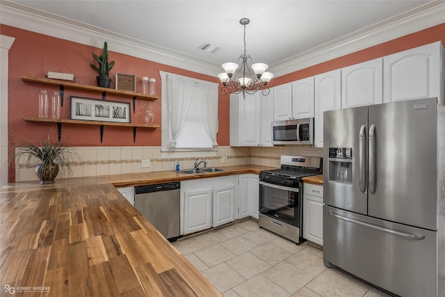 kitchen featuring wood counters, sink, hanging light fixtures, appliances with stainless steel finishes, and white cabinets