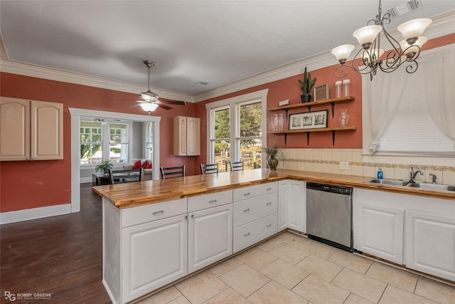 kitchen with butcher block countertops, tasteful backsplash, white cabinetry, hanging light fixtures, and dishwasher