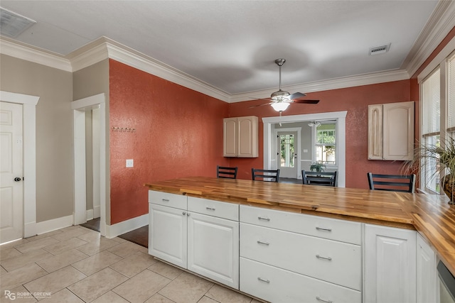 kitchen with crown molding, butcher block counters, and white cabinets