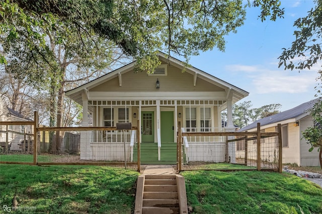 back of house with a yard and covered porch