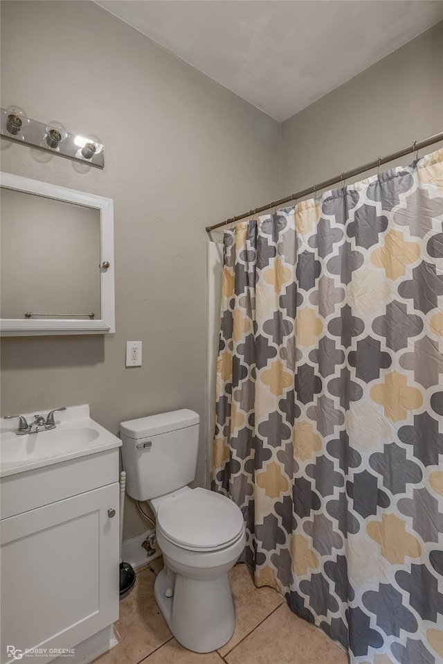 bathroom with tile patterned flooring, vanity, walk in shower, and toilet