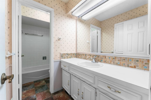 bathroom featuring tiled shower / bath and vanity