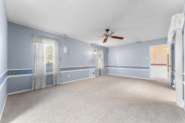 spare room featuring ceiling fan, carpet floors, and a textured ceiling