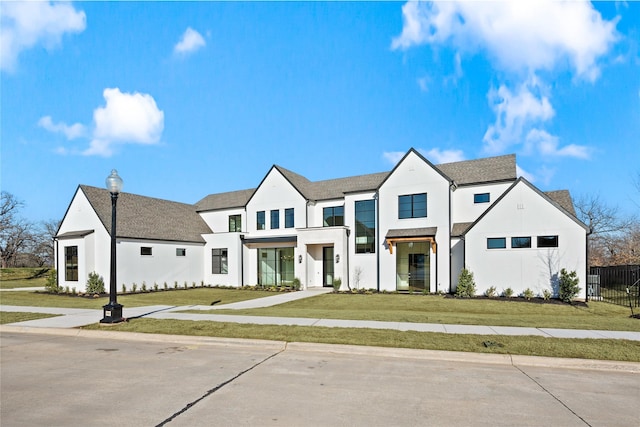 modern farmhouse style home with fence and a front yard