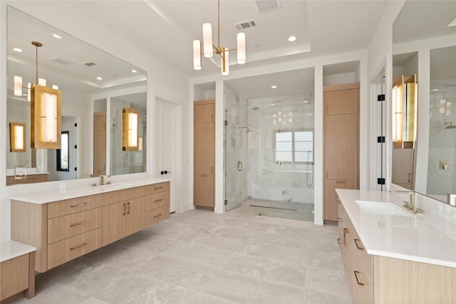 full bathroom featuring visible vents, a chandelier, two vanities, a stall shower, and a sink