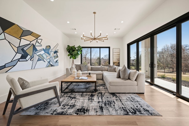 living area with recessed lighting, wood finished floors, visible vents, and a chandelier