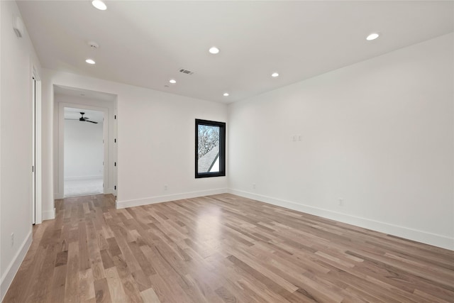 spare room with recessed lighting, light wood-type flooring, and baseboards