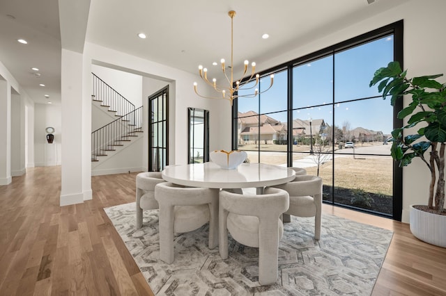 dining room featuring recessed lighting, stairway, light wood-style floors, and an inviting chandelier