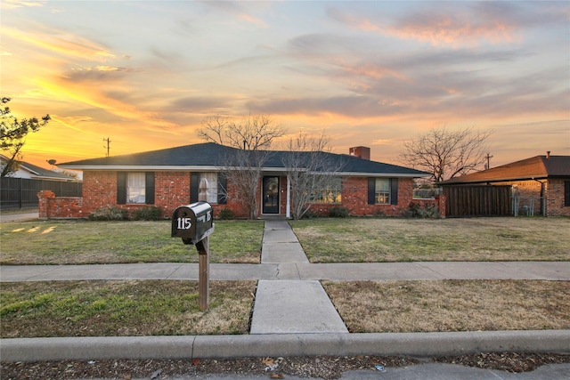 single story home with a lawn