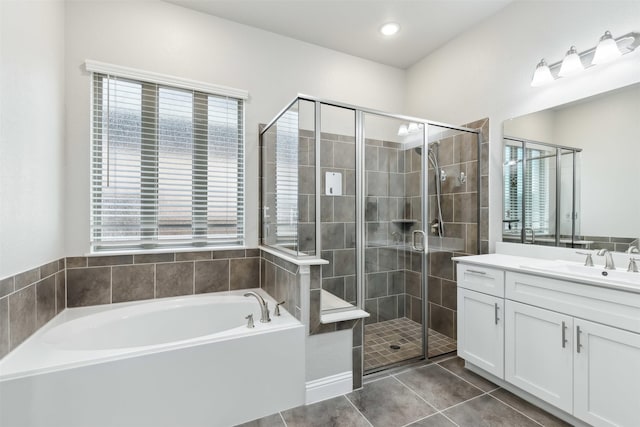 full bath featuring a stall shower, tile patterned flooring, a bath, and vanity