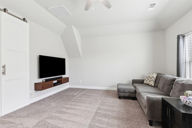 carpeted living area with a barn door, visible vents, baseboards, vaulted ceiling, and a ceiling fan