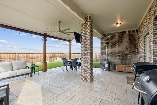 view of patio featuring a fenced backyard, an outdoor hangout area, a ceiling fan, and outdoor dining space