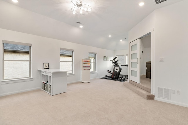 exercise area with vaulted ceiling and light carpet