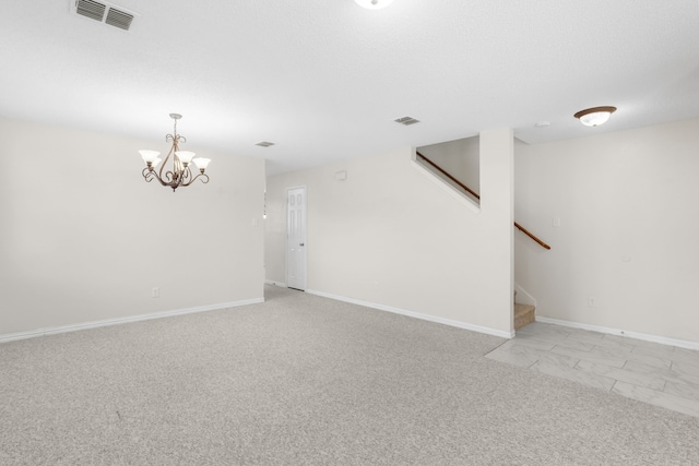 carpeted spare room with an inviting chandelier