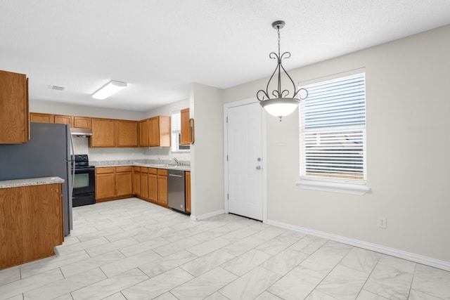 kitchen featuring hanging light fixtures, sink, a textured ceiling, and stainless steel appliances