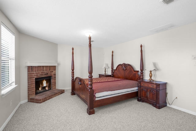 carpeted bedroom featuring a brick fireplace