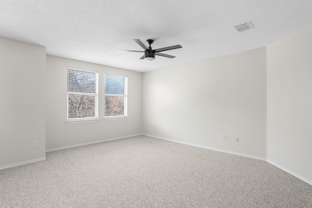 carpeted spare room featuring a textured ceiling and ceiling fan