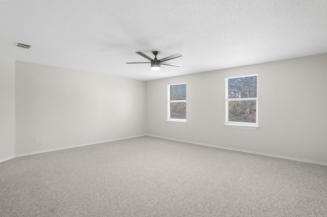 carpeted empty room featuring a textured ceiling and ceiling fan