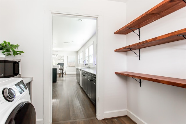 interior space featuring washer / clothes dryer, dark hardwood / wood-style flooring, and sink