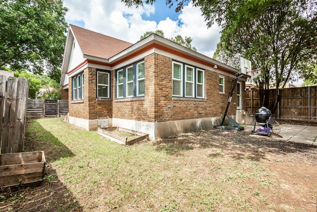 view of side of home with a lawn