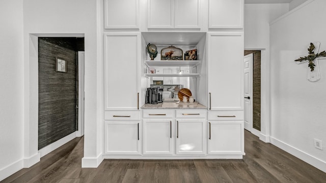 bar featuring dark hardwood / wood-style floors and white cabinets