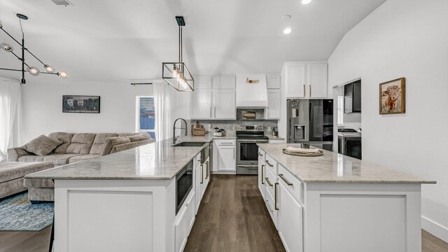 kitchen featuring a breakfast bar, sink, hanging light fixtures, electric stove, and white cabinets