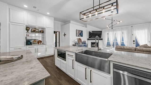 kitchen with sink, light stone counters, decorative light fixtures, appliances with stainless steel finishes, and white cabinets