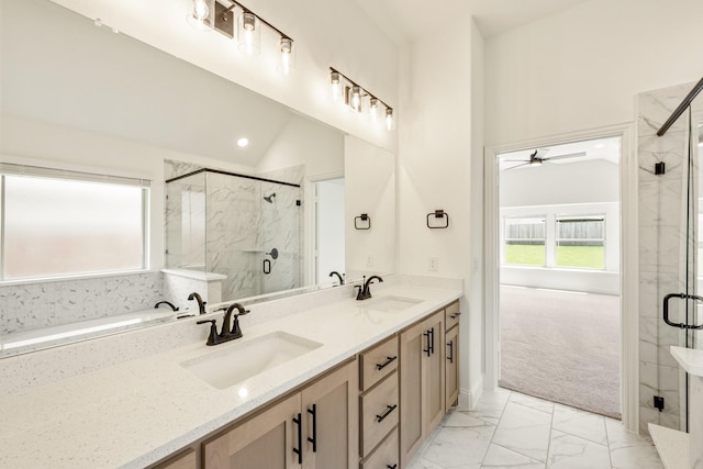 full bathroom featuring marble look tile flooring, ceiling fan, a marble finish shower, double vanity, and vaulted ceiling