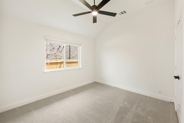 spare room with ceiling fan, carpet flooring, baseboards, and vaulted ceiling