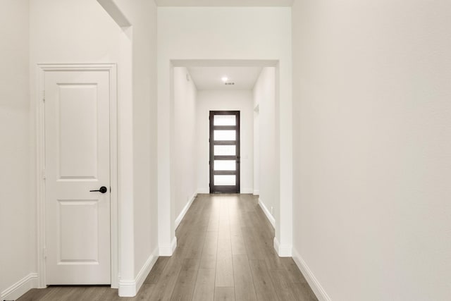 corridor with wood finished floors and baseboards