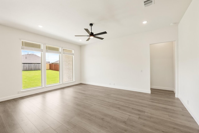 spare room featuring a ceiling fan, wood finished floors, recessed lighting, and baseboards
