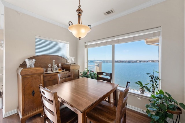 dining area featuring crown molding, a water view, and dark hardwood / wood-style floors