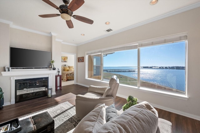 living room with a water view, ceiling fan, ornamental molding, and dark wood-type flooring