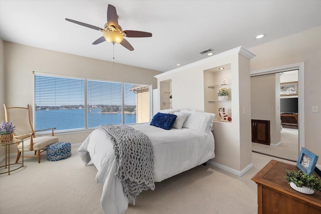 carpeted bedroom with a water view and ceiling fan