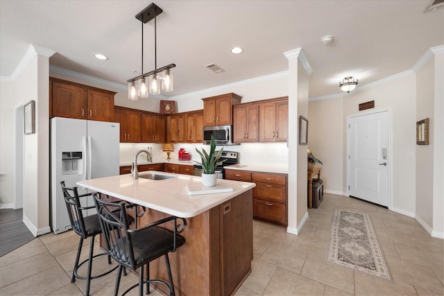 kitchen featuring light tile patterned flooring, a breakfast bar, sink, appliances with stainless steel finishes, and an island with sink