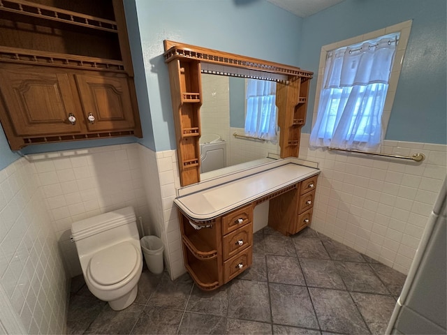 bathroom featuring toilet and tile walls