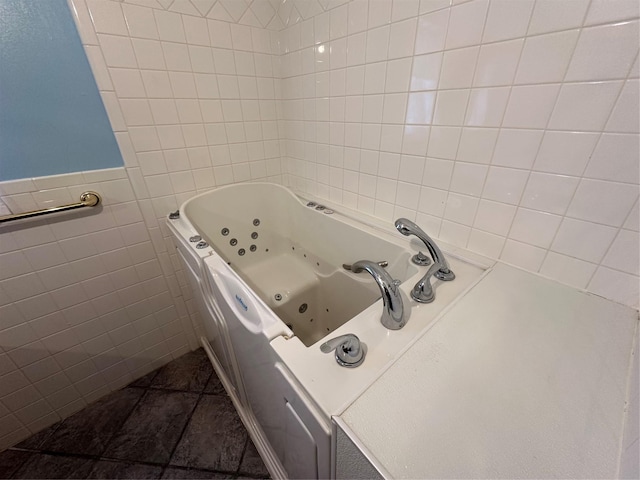 bathroom with a bathing tub, tile walls, and tile patterned floors