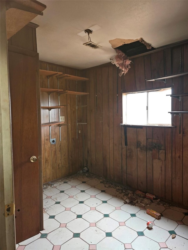 unfurnished room featuring wood walls