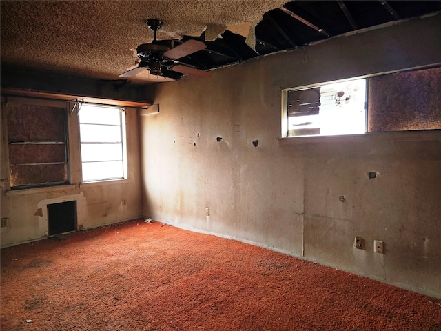 carpeted empty room with a textured ceiling and ceiling fan