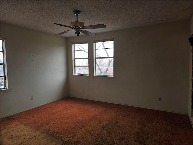 carpeted empty room with a textured ceiling and ceiling fan